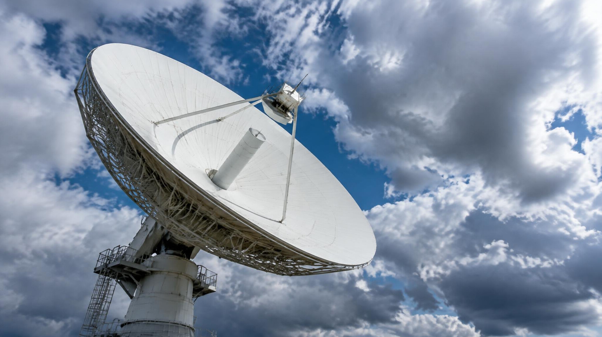Large satellite dish against a dramatic sky