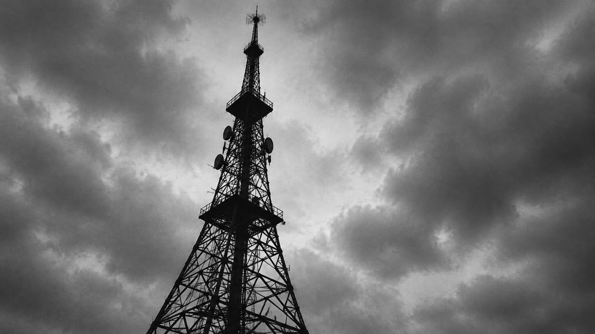 Vintage radio transmission tower against a dramatic sky