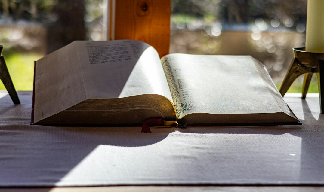 Old open book with yellowed pages on a wooden table
